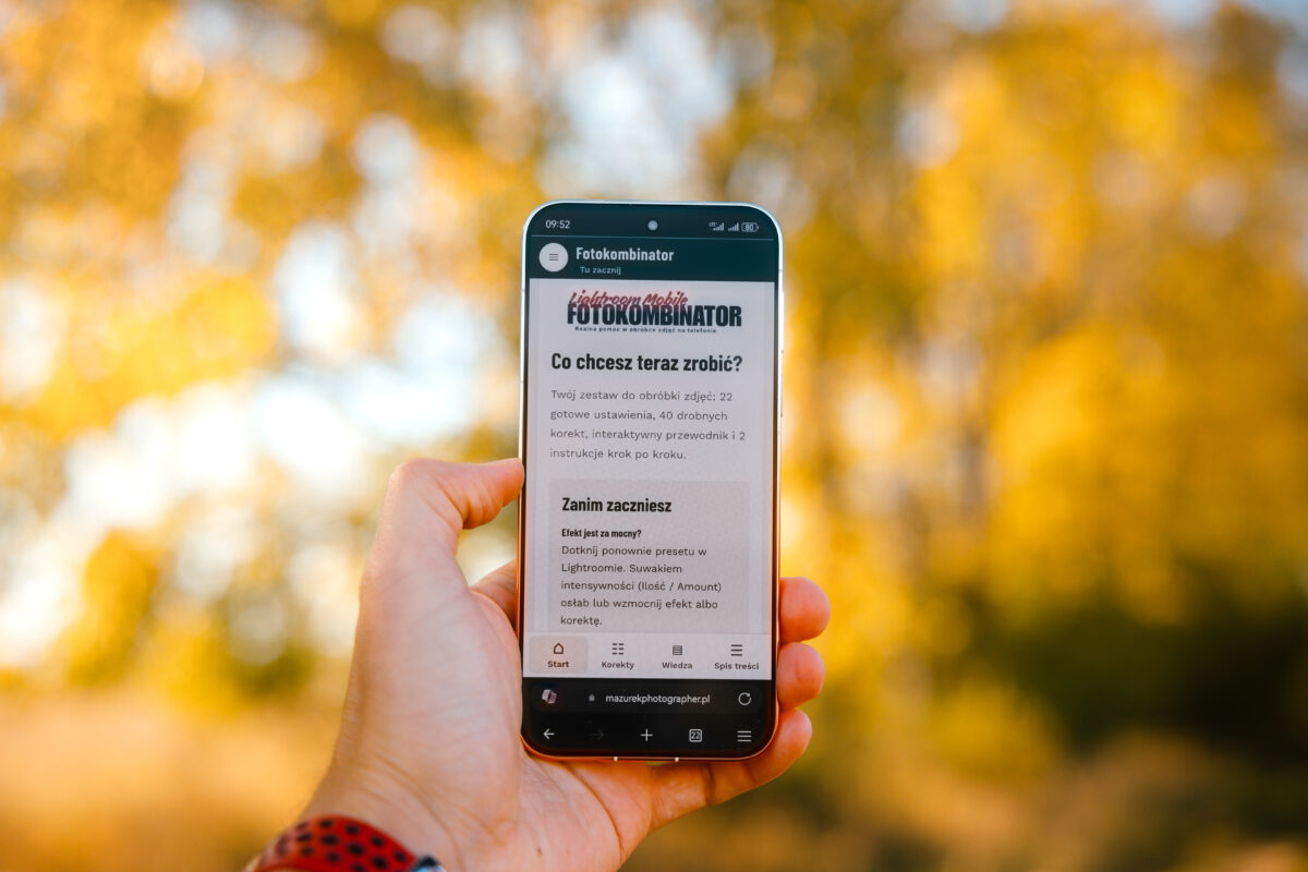 Smartfon z otwartym Fotokombinatorem w dłoni na tle jesiennych liści